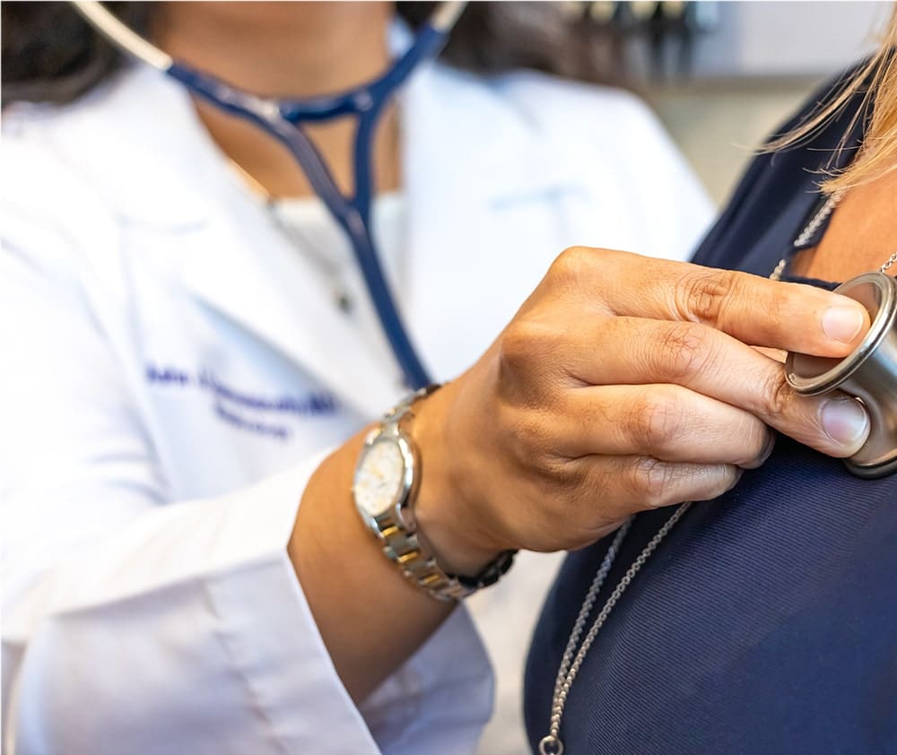 A doctor using a stethoscope on a patient