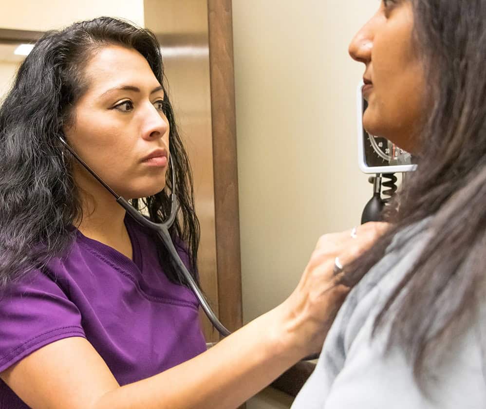 A doctor using a stethoscope on a patient